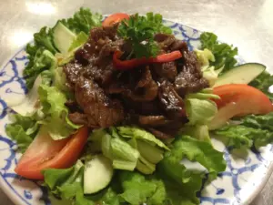 Grilled beef over fresh greens and cucumber, a Thai-style beef salad from Thai House Restaurant