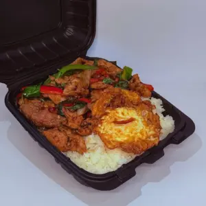 Basil stir-fry topped with a fried egg over rice in a to-go box from Anchan Thai Fusion