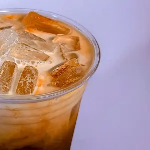 Iced Thai milk tea in a clear cup from Anchan Thai Fusion