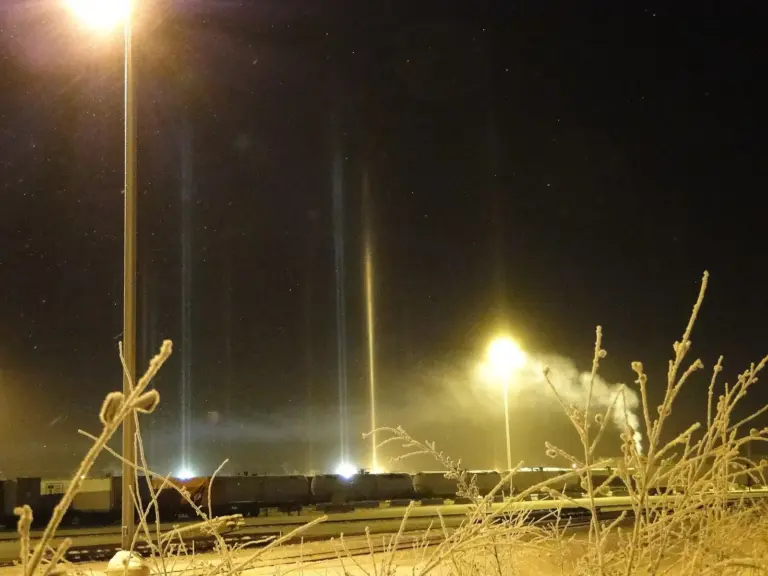 Light pillars rising through ice fog at the Fairbanks train station at night