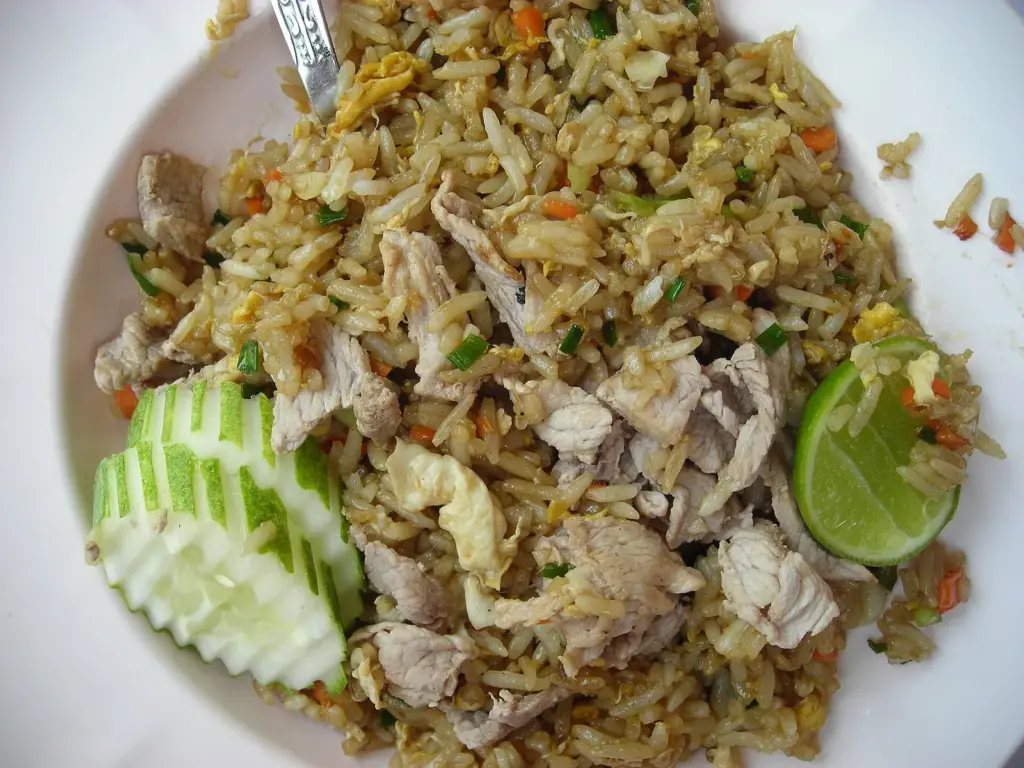 Thai pork fried rice with cucumber slices and lime