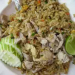 Thai pork fried rice with cucumber slices and lime