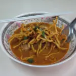 Bowl of khao soi, the spicy coconut curry noodle soup of northern Thailand