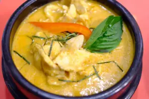 Golden Thai curry garnished with basil and red chili at Lemongrass Thai Cuisine