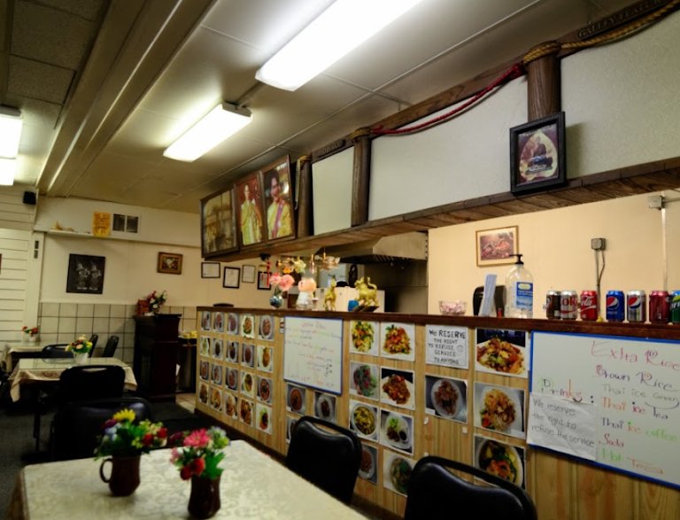 Dining room at Nims Thai restaurant in Fairbanks with a counter lined with dish photos