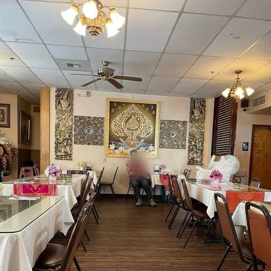 Thai House dining room in Fairbanks, with gold Thai artwork and white tablecloths