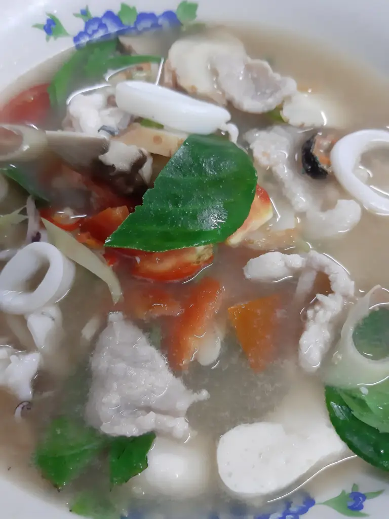 Clear tom yum soup with seafood, mushrooms and herbs