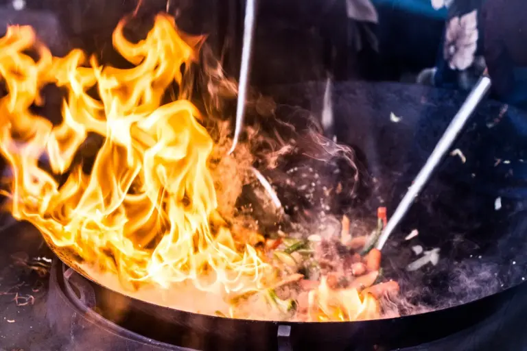 Flames leaping from a wok during stir-frying