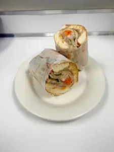 Halved rice-paper wrap on a white plate at Yes! Noodle Soup